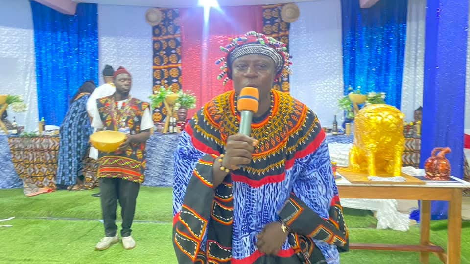 Speaker in traditional Talla regalia addressing the hall